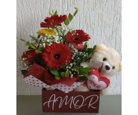 Arranjo de rosas e urso de pelúcia.